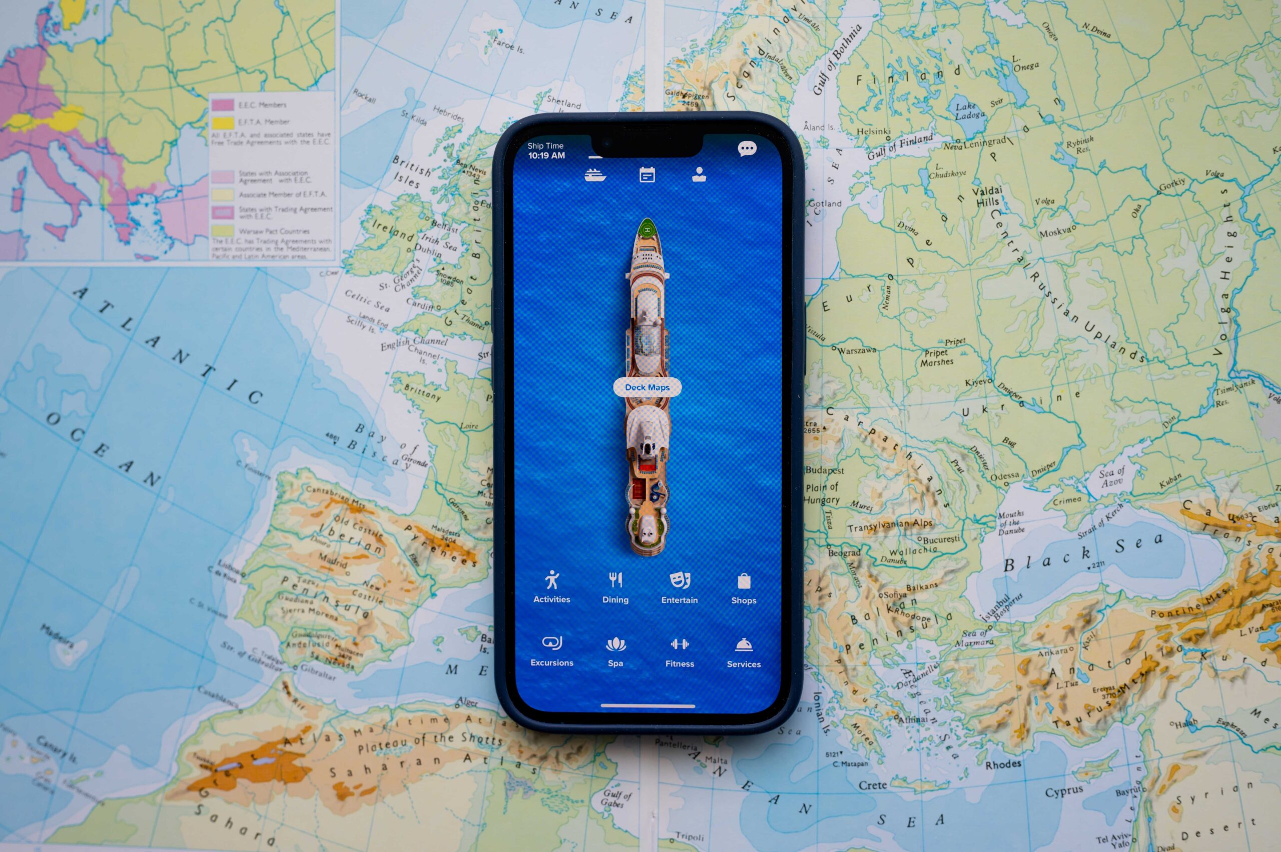 A mobile phone with a cruise app on screen in front of a map